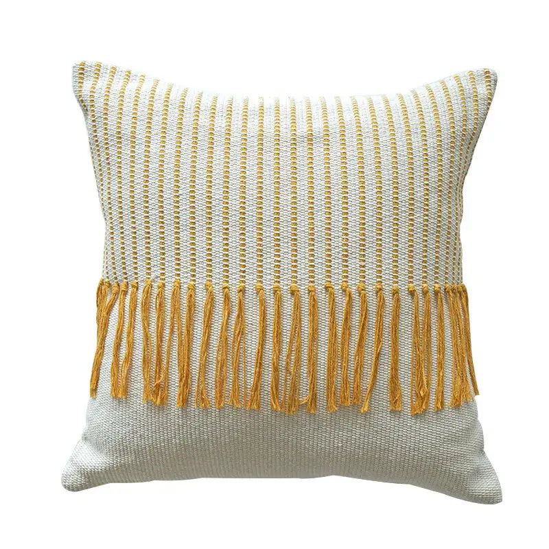 A boho moroccan fringed square cushion with textured white and mustard yellow woven pattern and tassel decorbites pillowcase