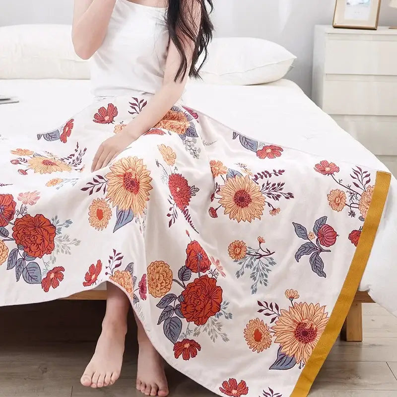 A flowing white maxi skirt with vibrant orange red floral patterns and golden trim complements decorbites cotton bath towel