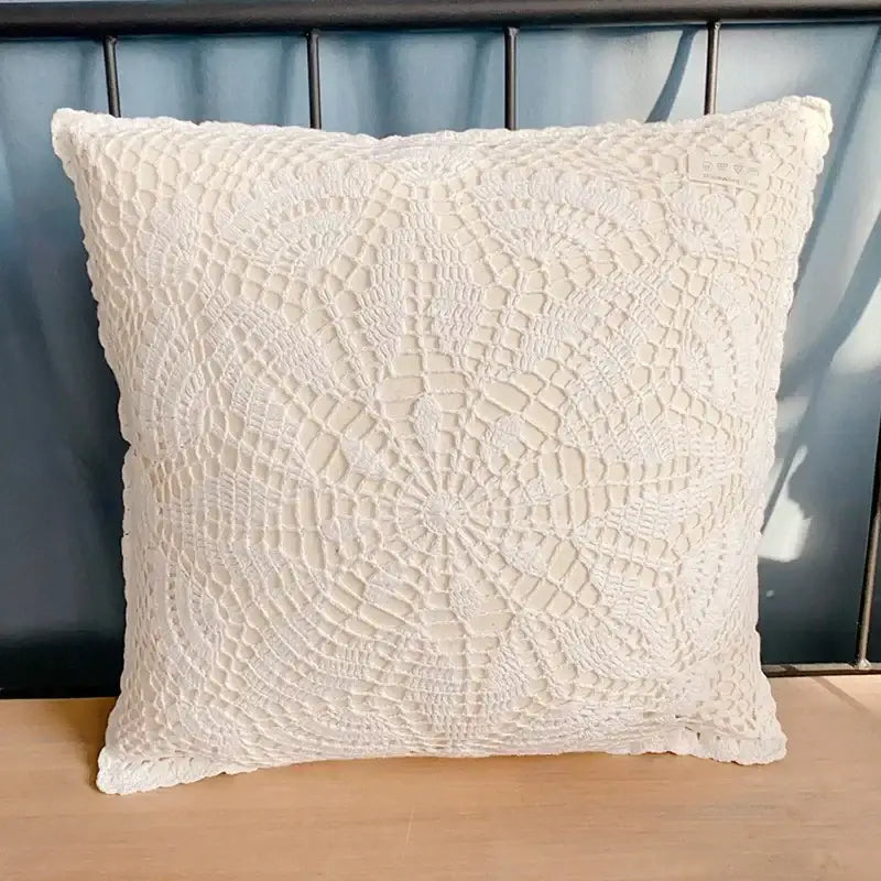 Cream-colored crochet cushion cover with delicate lace pattern and frayed edges for boho living room decorbites decor