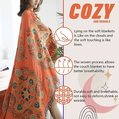 A cozy orange decorbites gauze boho towel blanket with intricate dark green floral patterns and soft fringed edges