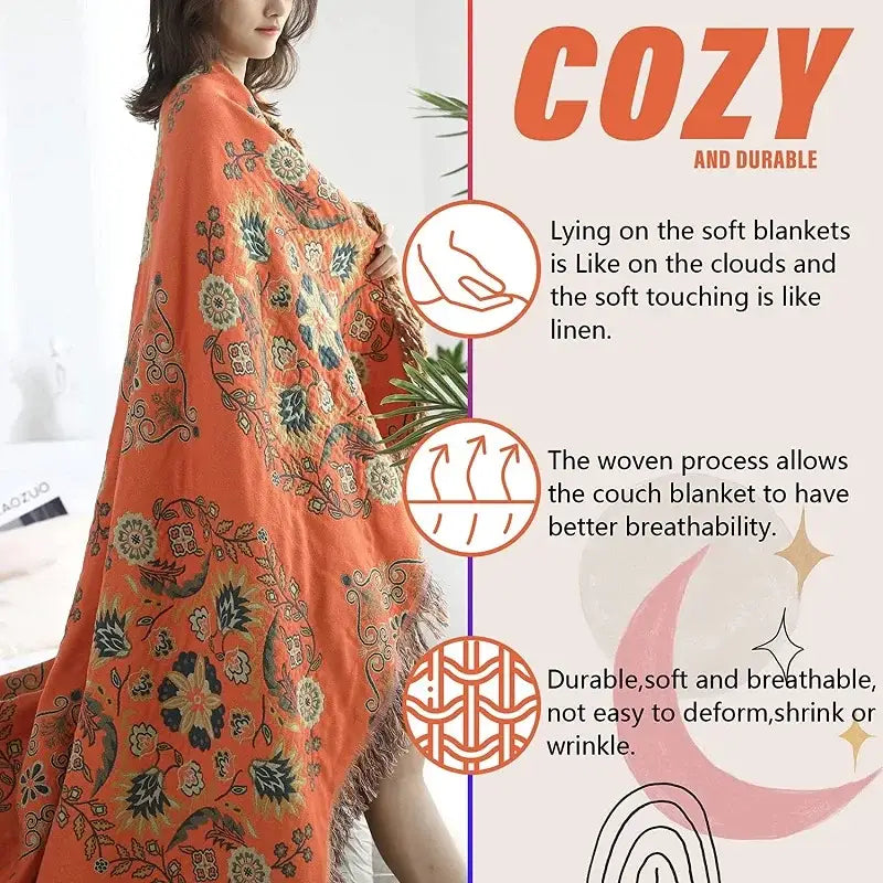 A cozy orange decorbites gauze boho towel blanket with intricate dark green floral patterns and soft fringed edges