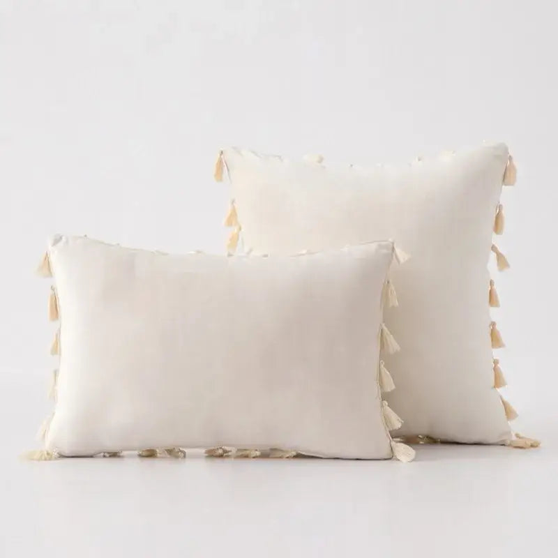 Cream-colored rectangular pillow covers with soft tassel fringe trim ideal for boho home decor accents