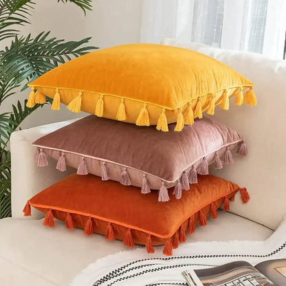 Stacked boho velvet pillow covers in mustard yellow dusty rose and burnt orange with tassel fringe for home decor