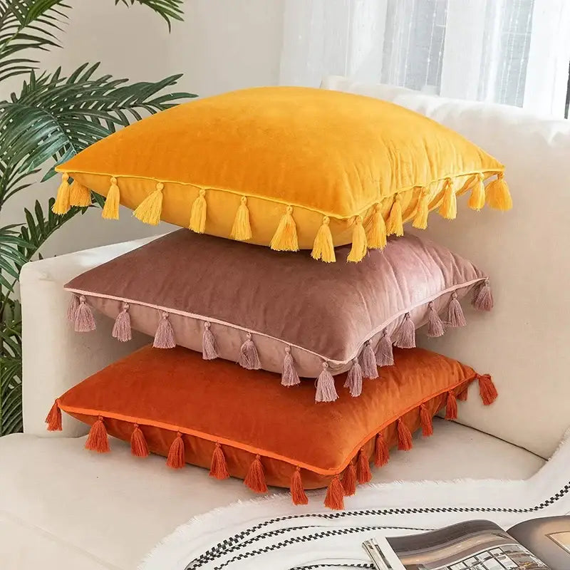 Stacked boho velvet pillow covers in mustard yellow dusty rose and burnt orange with tassel fringe for home decor