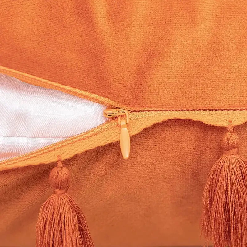 Orange velvet pillow cover with tassel fringe and gold-toned zipper for boho home decor pillow covers