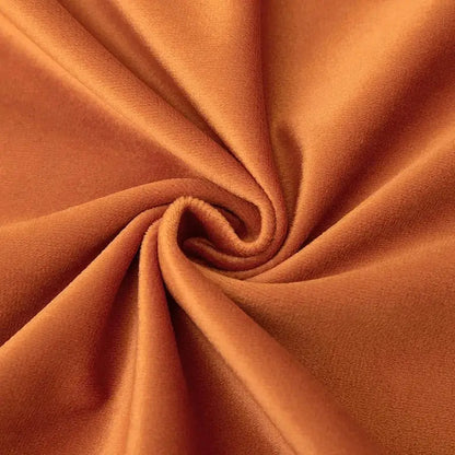Rich rust-colored velvet pillow covers with tassel fringe featuring soft plush texture for boho home decor