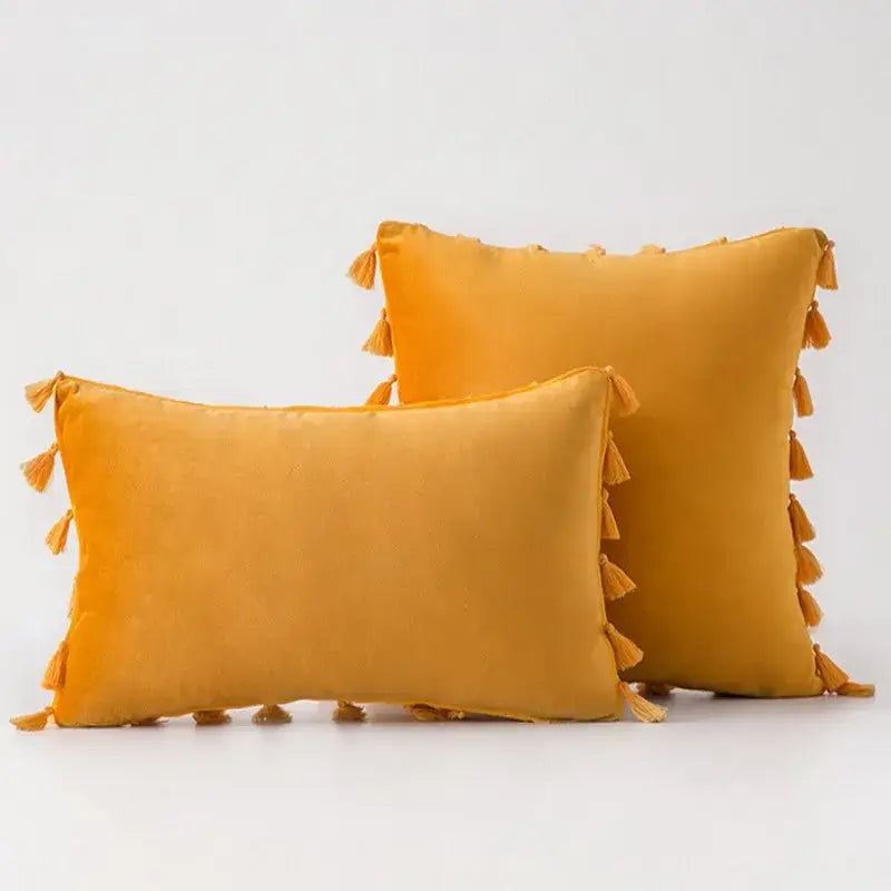 Warm mustard-yellow velvet pillow covers with decorative tassel fringe for boho living room home decor