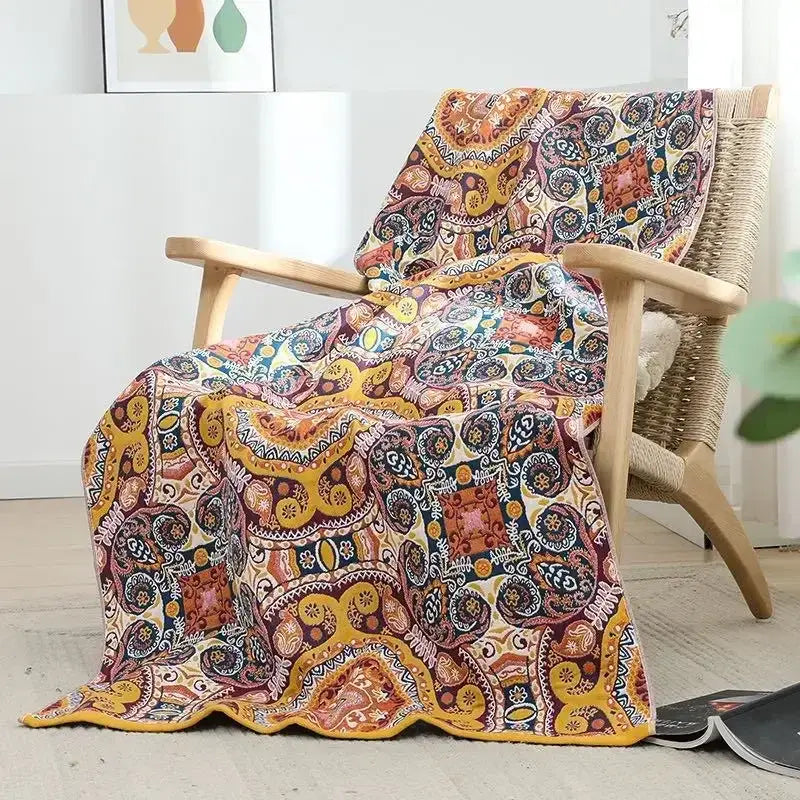 A cozy multicolored paisley cotton gauze bath towel draped over a wooden chair for bathroom wrap use