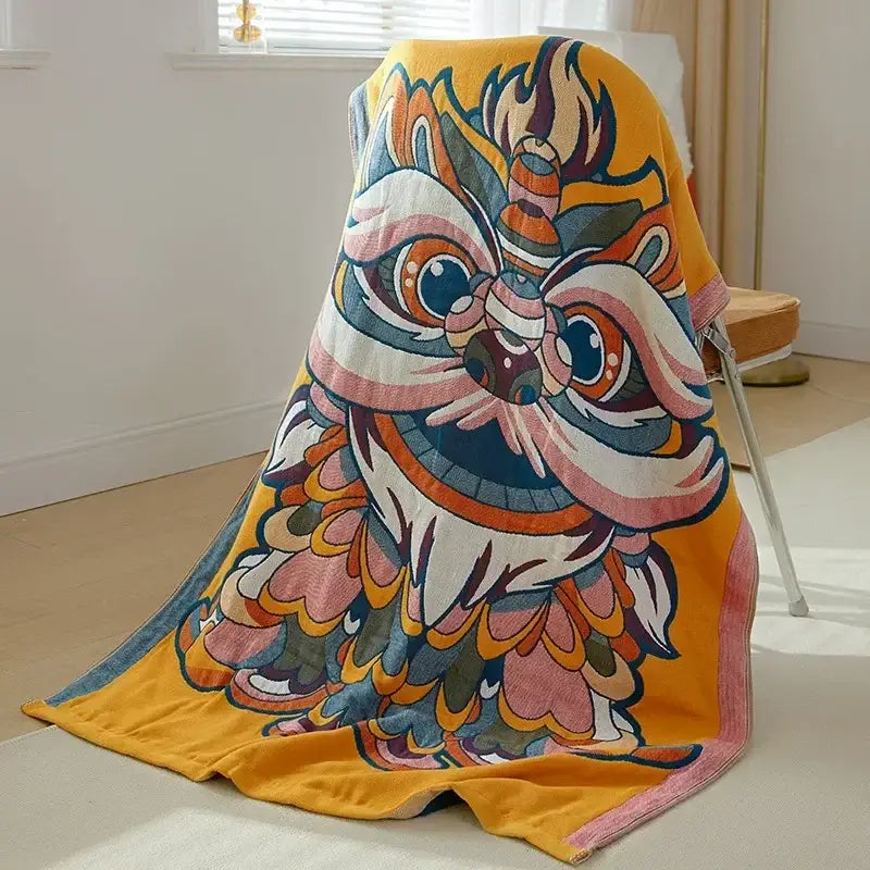 A vibrant yellow boho patchwork cotton gauze bath towel with an embroidered chinese lion dance mask design