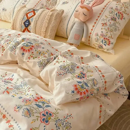 Cream-colored floral bedding set featuring embroidered boho pattern printed blossoms in soft reds, oranges, and blues by decorbites