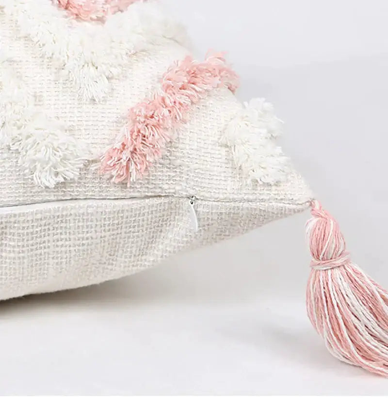 Cream-colored boho pink geometric pillow cover with pink and white tassels and textured woven fabric by decorbites