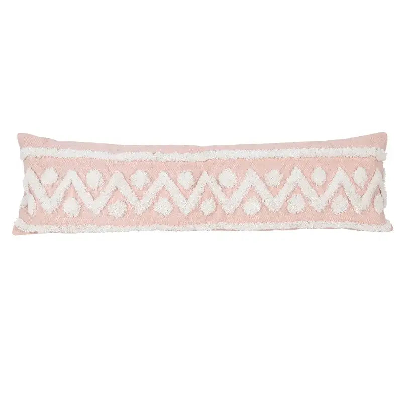 A soft pink boho pink geometric pillow cover with white zigzag pattern and pom-pom accents for decorbites decor