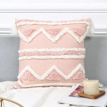 A soft pink boho pink geometric pillow cover with white patterns and tassels for bedroom decorbites decor