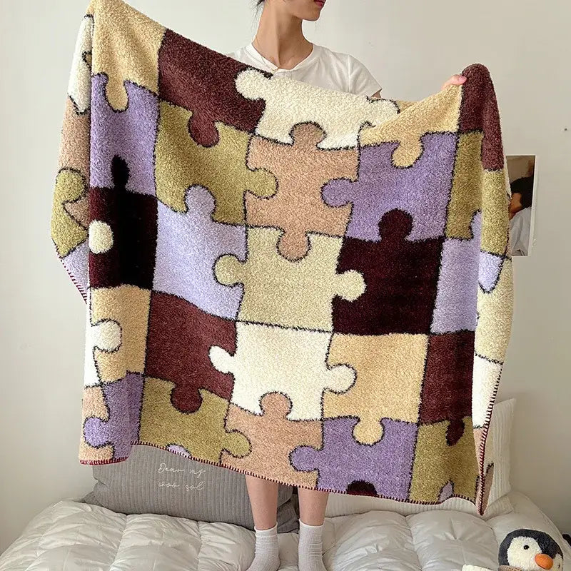 A cozy boho printed blanket with a patchwork puzzle design in earthy tones made from chunky knit material