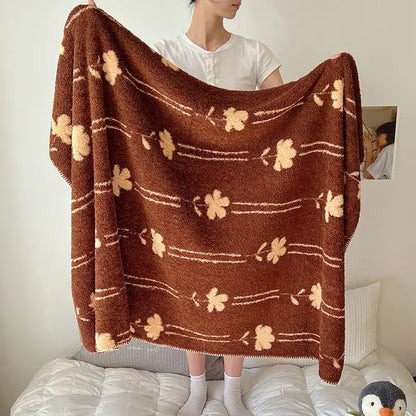 A cozy brown plush boho printed blanket with beige floral patterns and thin white lines, perfect for bedroom use