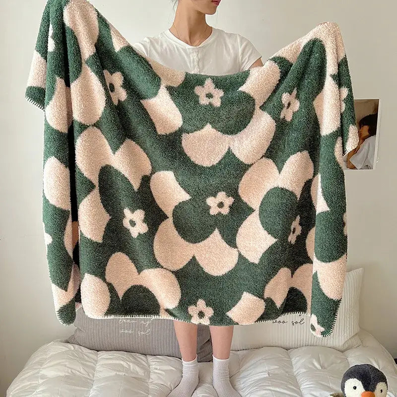 A plush green and cream boho printed blanket with floral pattern and chunky knit texture for cozy bedrooms