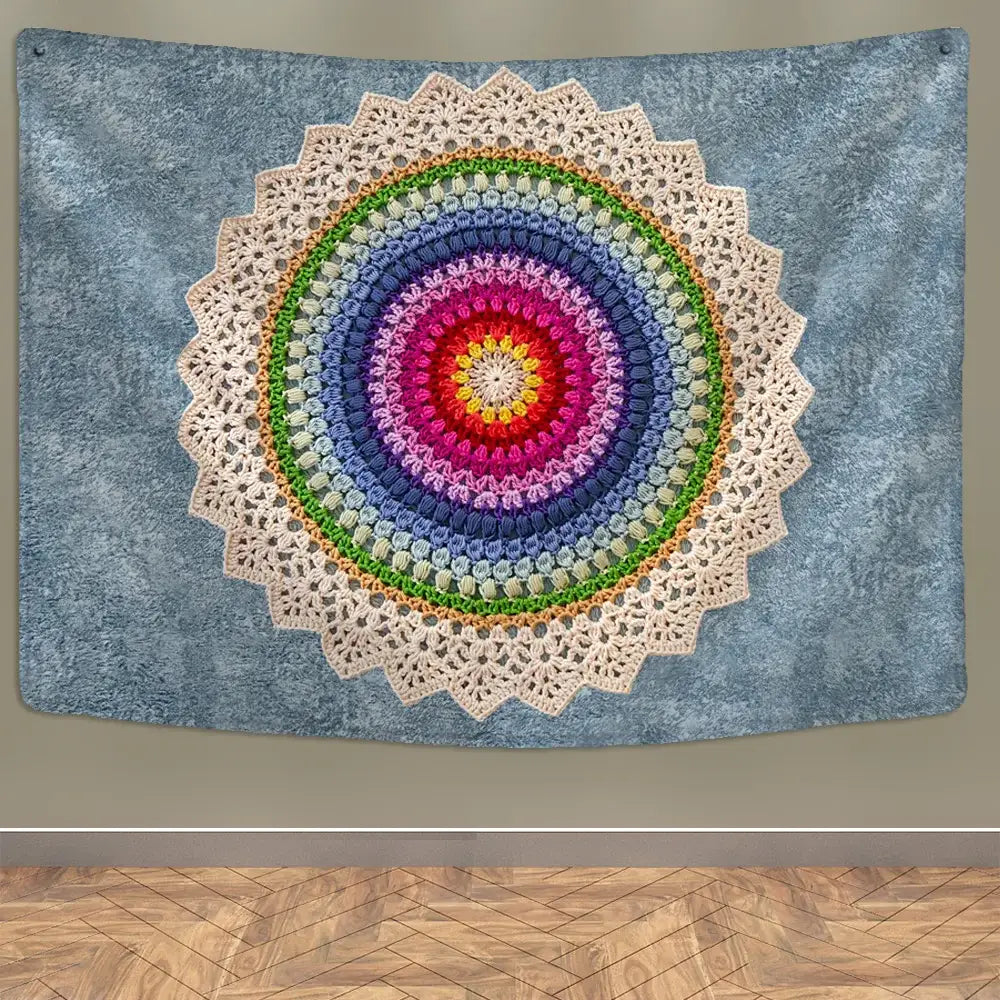 Vibrant rainbow-colored crocheted boho indian mandala wall hanging with cream lace border on textured blue wall decorbites indian mandala