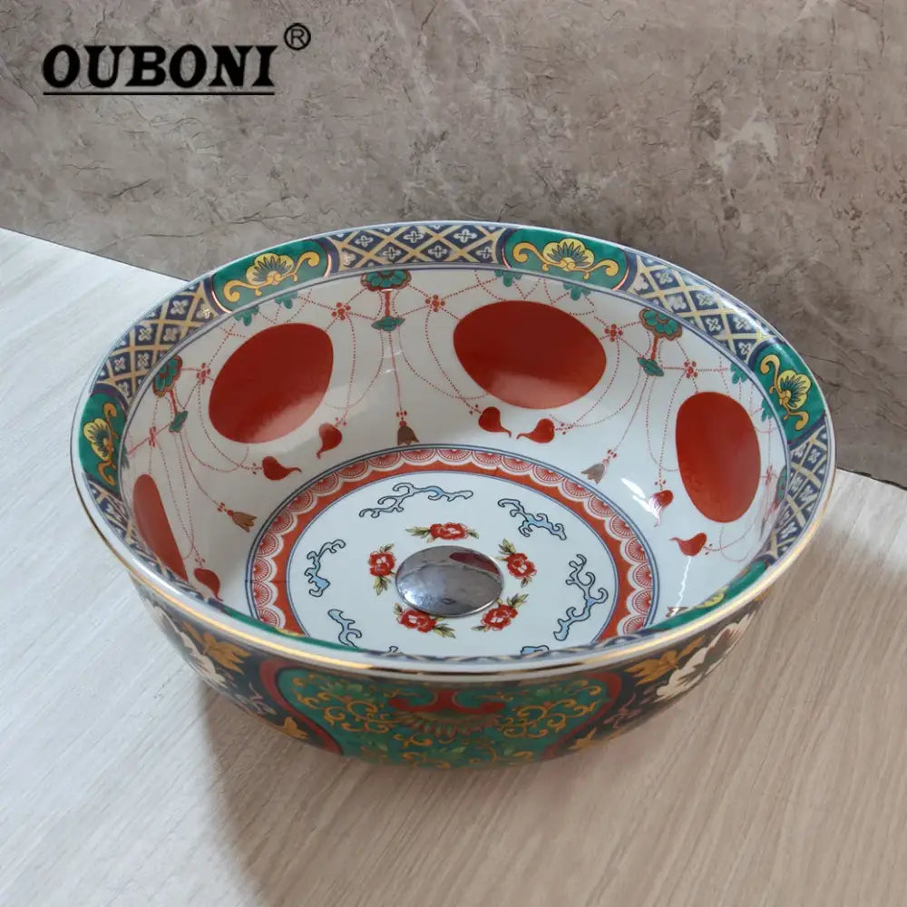 Ouboni boho retro ceramic bathroom sink with intricate red green and gold floral pattern on white background