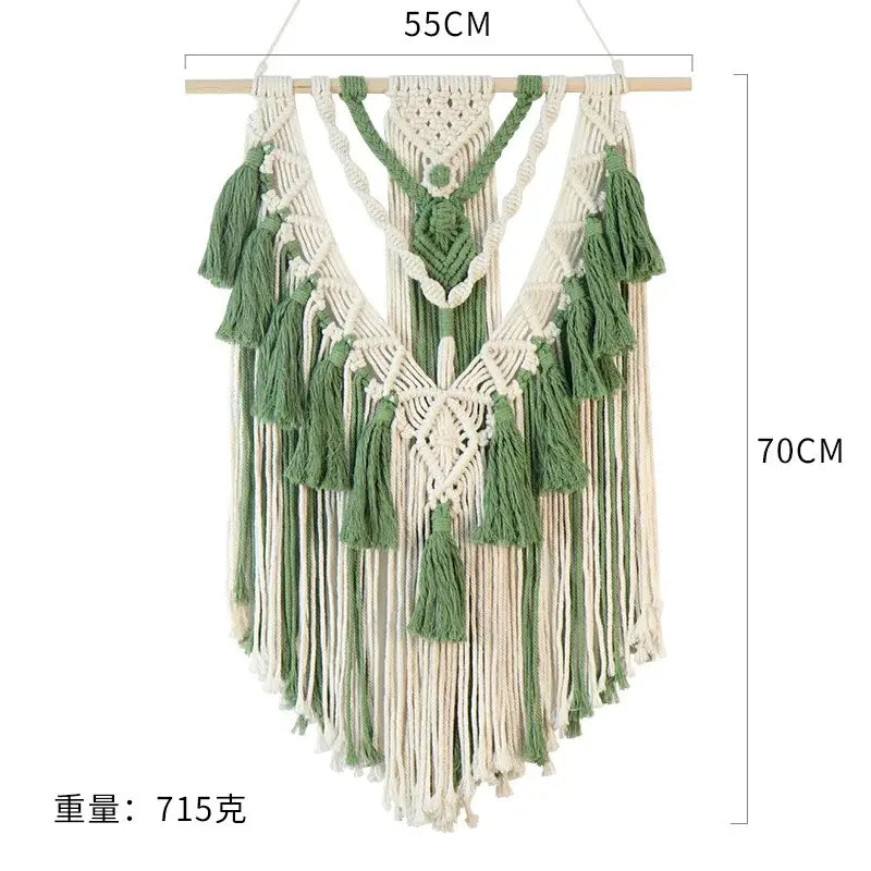 A cream and sage green macrame tassel stick wall hanging with intricate woven patterns and fringe for bedroom art