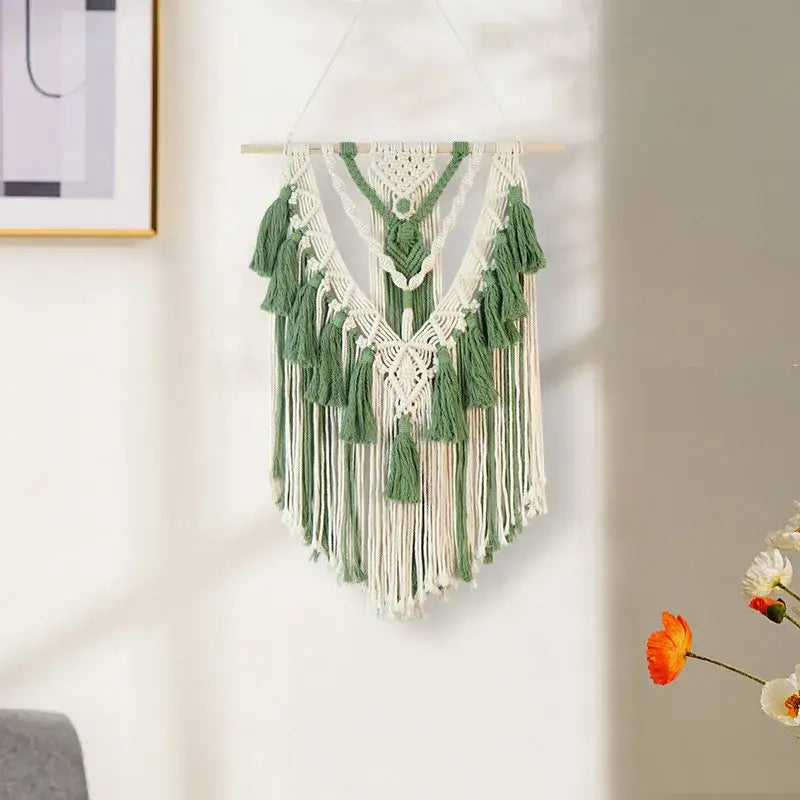 A delicate boho wall hanging featuring intricate white and sage green macrame tassel stick patterns for bedroom art