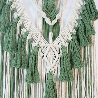 Boho sage green and white wall hanging featuring an intricate macrame tassel stick with symmetrical cords and diamond pattern