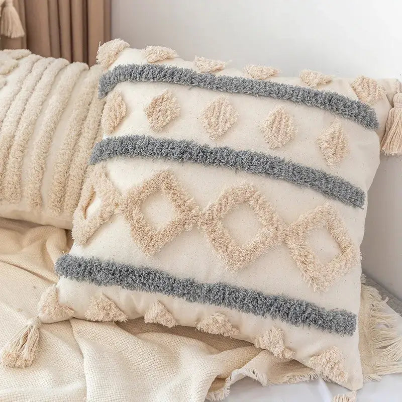 Cream-colored decorbites boho square pillowcase with textured gray beige geometric patterns and white teal tassels