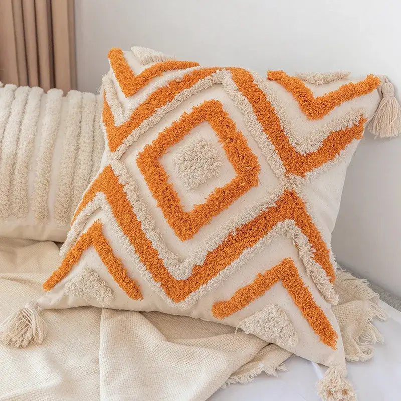 Cream-colored decorbites boho square pillowcase with orange and cream geometric embroidery and tassels for living room decor