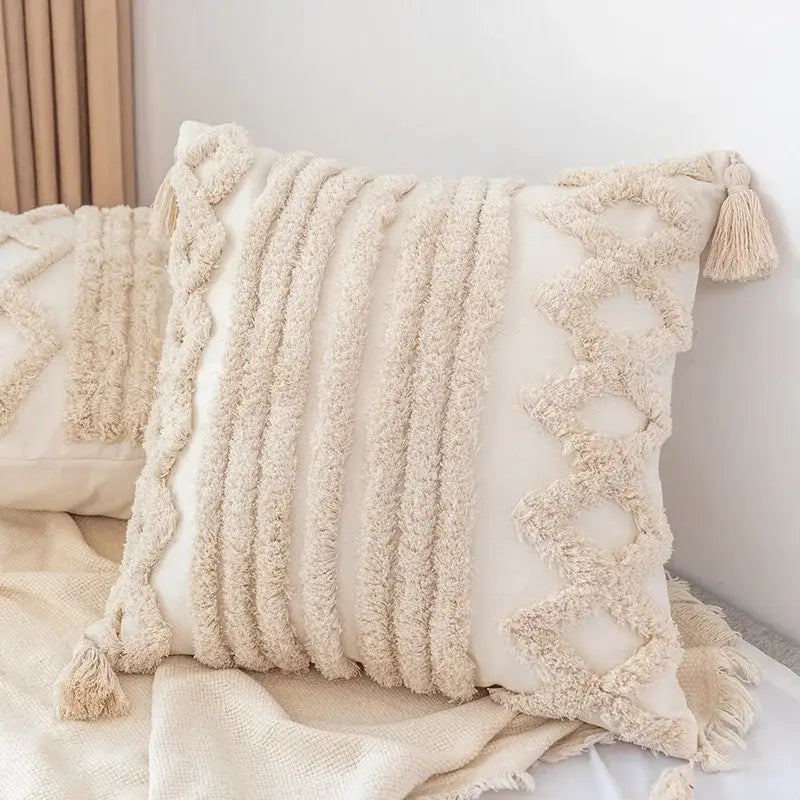 Cream-colored decorbites boho square pillowcase with textured fluffy tassels and braided cord accents for living room decor