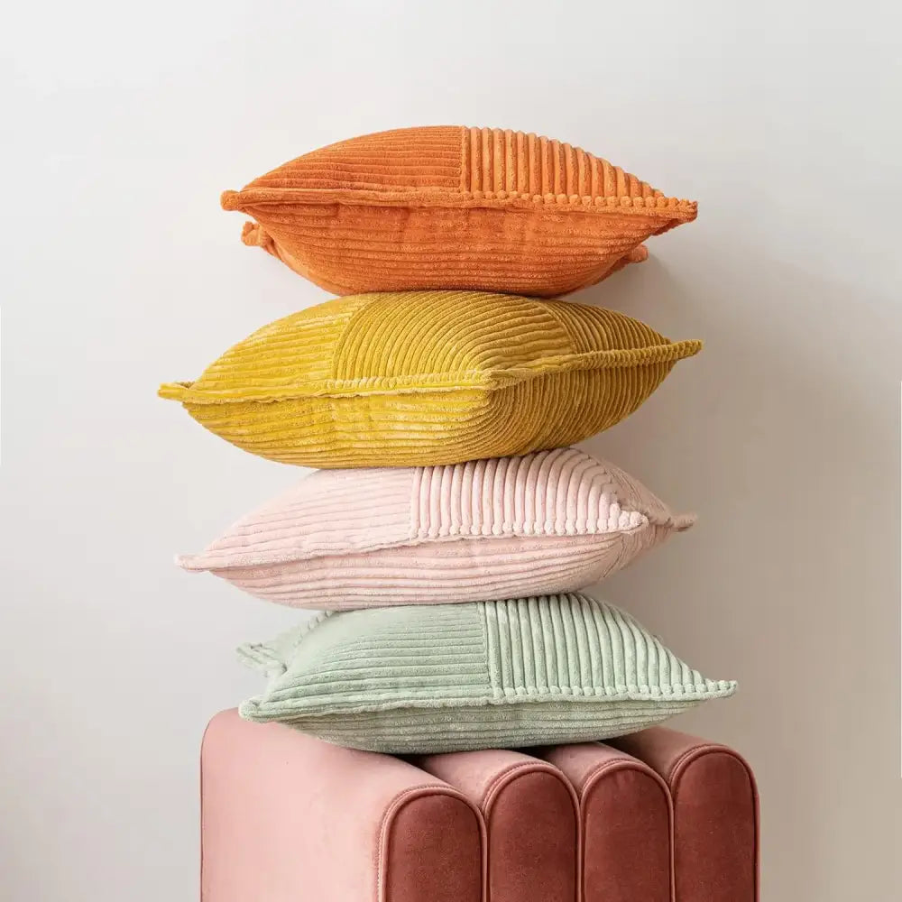 Stack of four colorful corduroy pillow covers in orange yellow pink and mint green for boho striped pillow decor