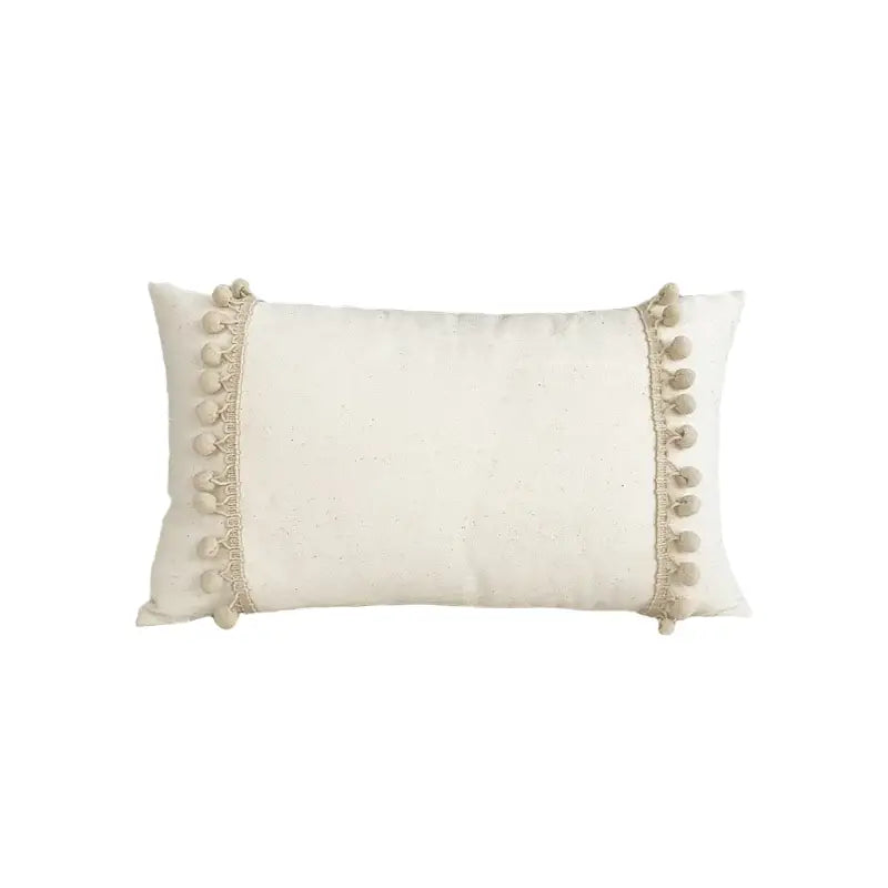 Cream-colored boho style linen cushion cover with soft pom-poms for stylish living room decor by decorbites boho style