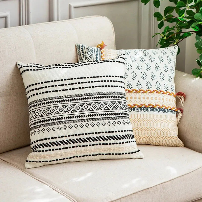 Cream-colored boho style cotton pillow cover with black geometric patterns and woven tassel trim decorbites boho style