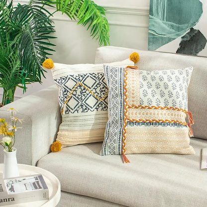 Two boho style cotton decorative pillow covers with cream and navy blue geometric designs and mustard tassels for living room decorbites boho style