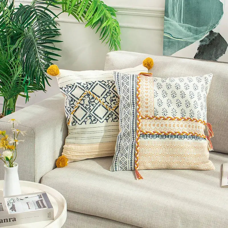 Two boho style cotton decorative pillow covers with cream and navy blue geometric designs and mustard tassels for living room decorbites boho style