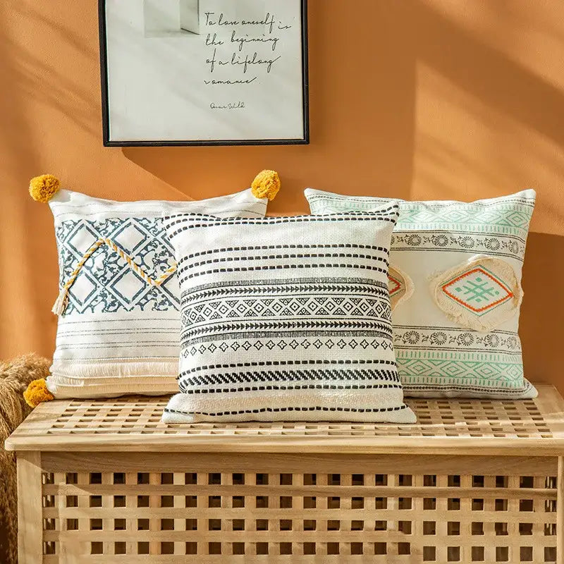 Three boho style cotton embroidered pillow covers with black white and mint geometric patterns tassels and fringed edges