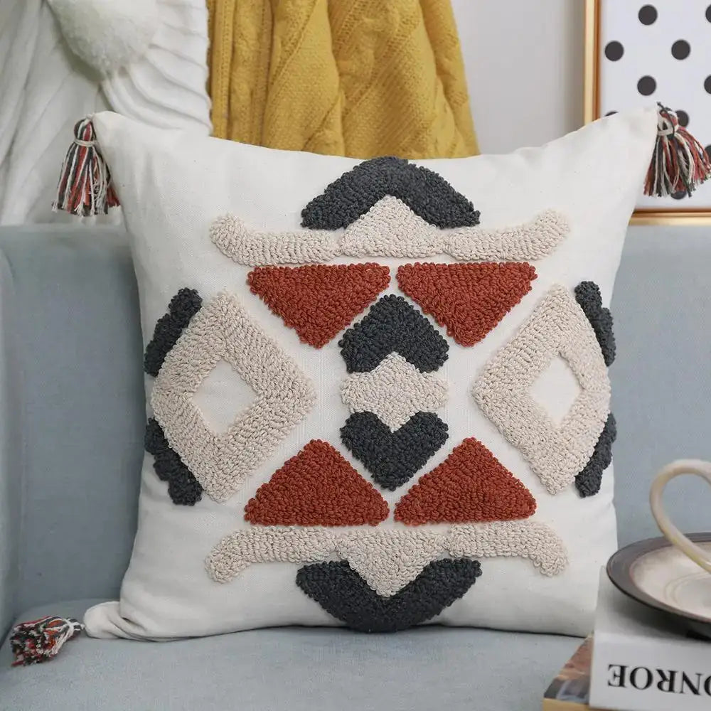 White throw pillow cover with beige rust red and dark gray woolen boho style embroidered pattern and multicolored tassels