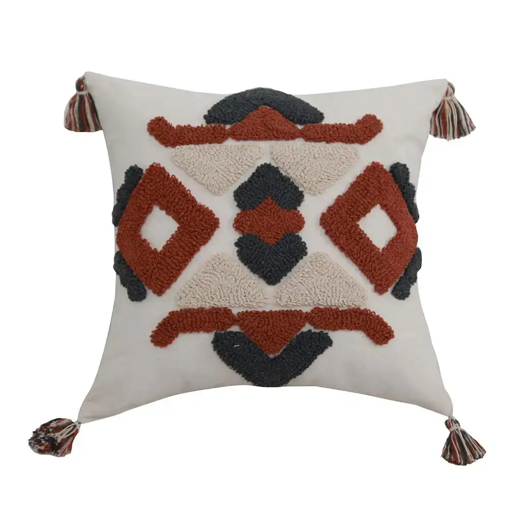 Cream-colored boho style embroidered pillow cover with textured geometric rust and charcoal pattern and tassels decorbites