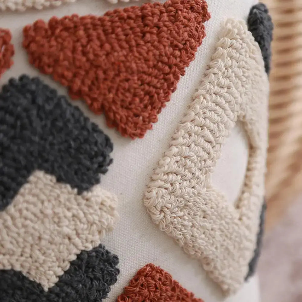 Cream-colored boho style embroidered pillow cover with chunky yarn geometric pattern in rust black and beige decorbites style