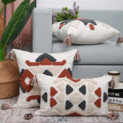Cream-colored boho style embroidered pillow cover with rust geometric embroidery and multicolored tassels decorbites decorbites