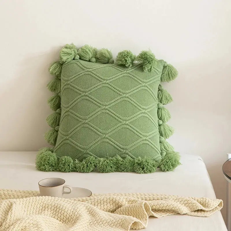 A soft sage green knitted cushion cover with diamond pattern and tassels for decorbites boho style ivory decor