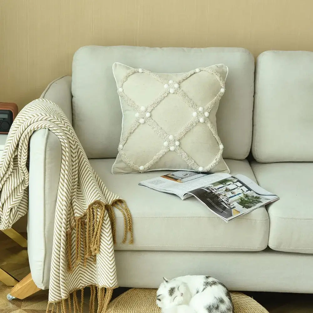 Beige boho style ivory cushion cover with textured crosshatch pattern and white pom pom accents for decorbites decor