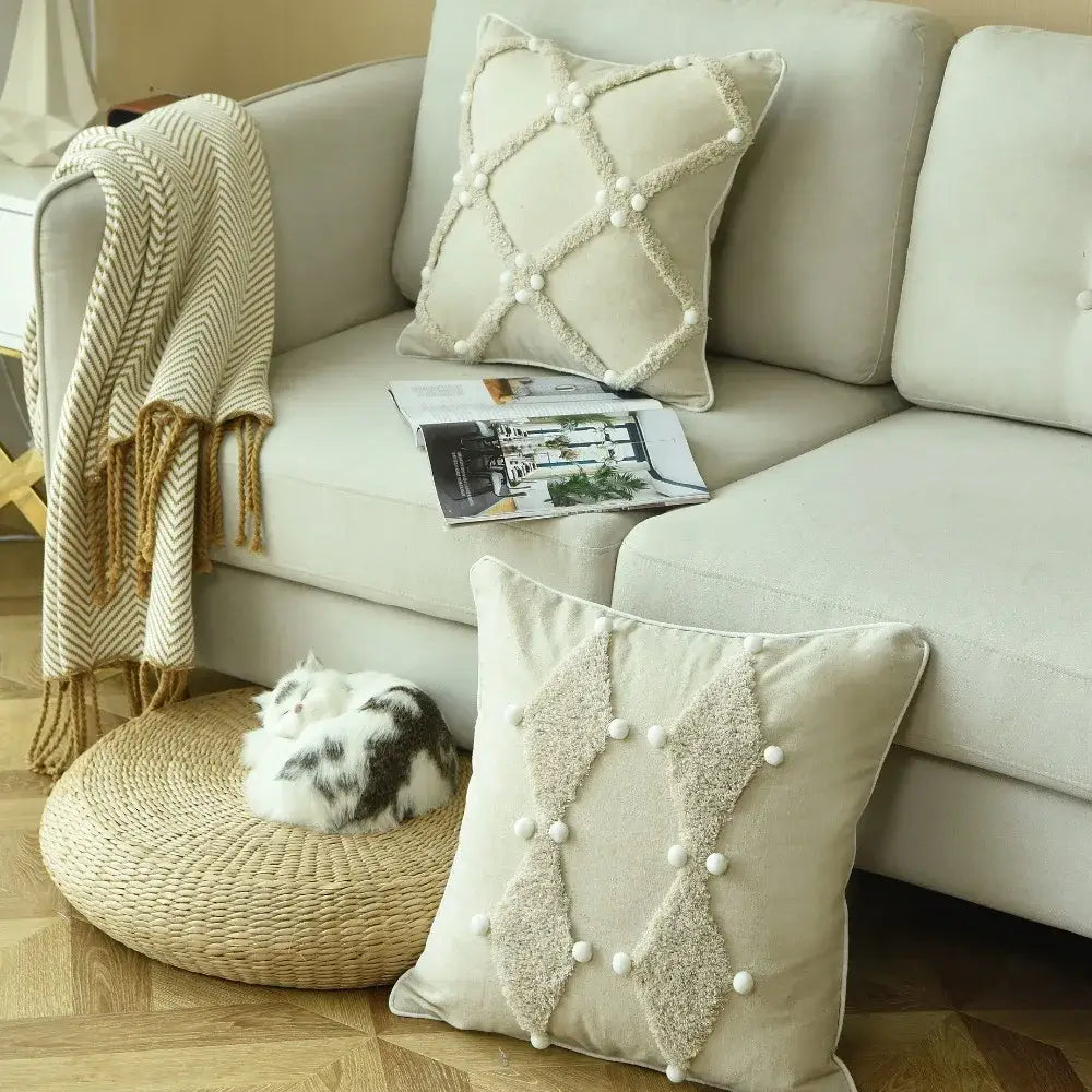 Beige boho style ivory cushion cover with textured diamond fabric and white pom pom accents for living room decor