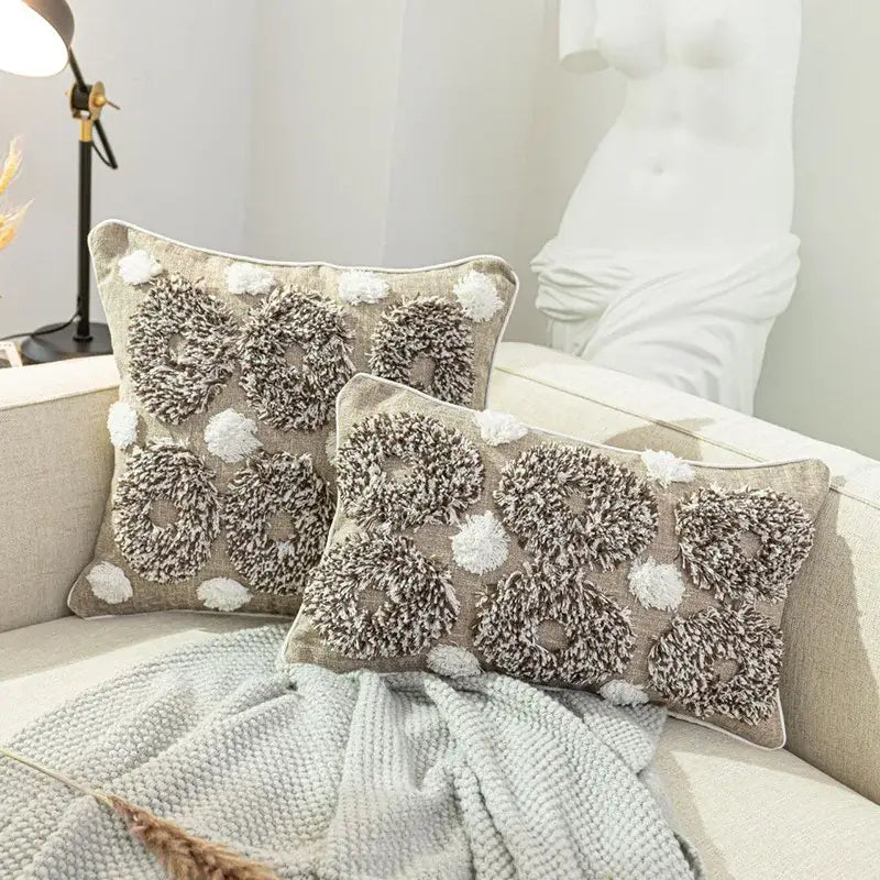 Boho style tufted beige and brown cushion cover with textured fluffy circular patterns and white pom-poms by decorbites