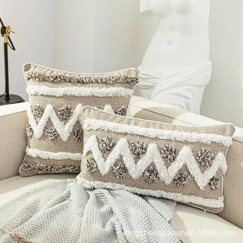 Beige rectangular throw pillows with white and brown fringe, zigzag embroidery, and pom-poms for decorbites boho style tufted cushion cover