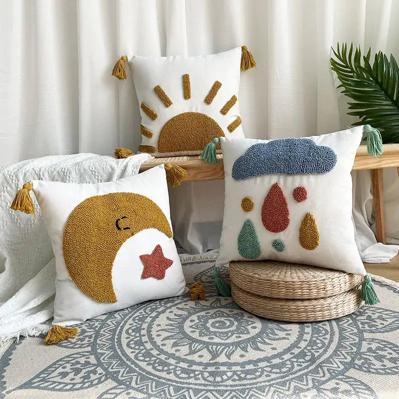 White cushion with colorful embroidered sun moon and cloud designs with mustard yellow and teal tassels decorative pillowcases 45x45