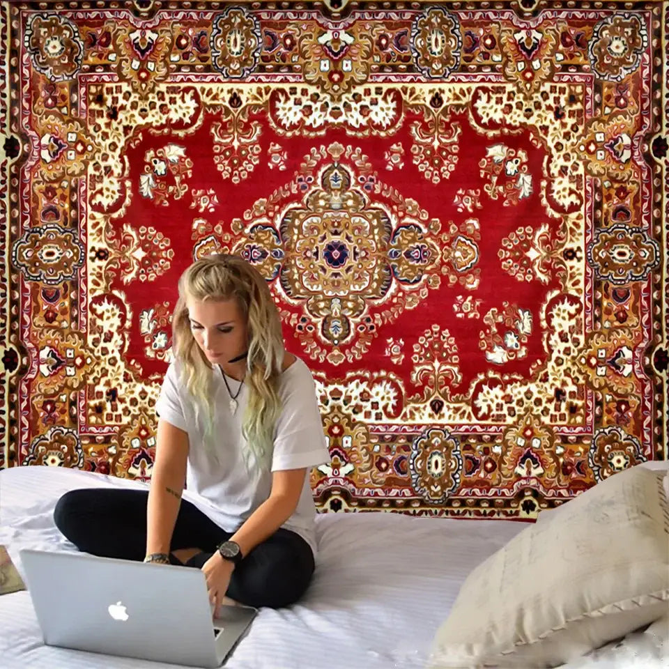 A silver apple laptop on a white bedspread beside a red and gold decorbites boho tapestry set for bedroom decor