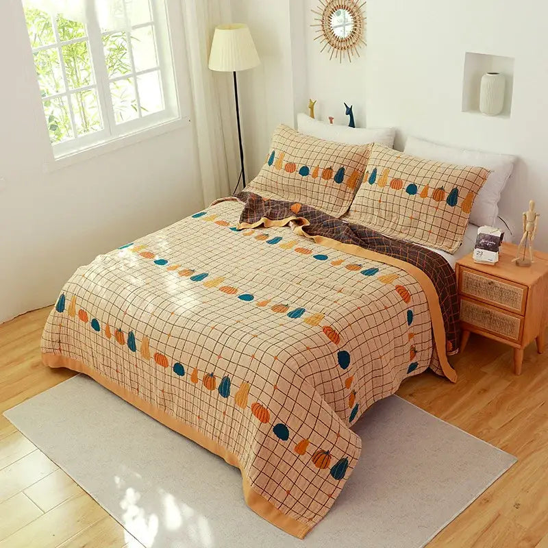 Beige quilted cover throw blanket with colorful pumpkin motifs in orange teal and brown for boho bedroom decor