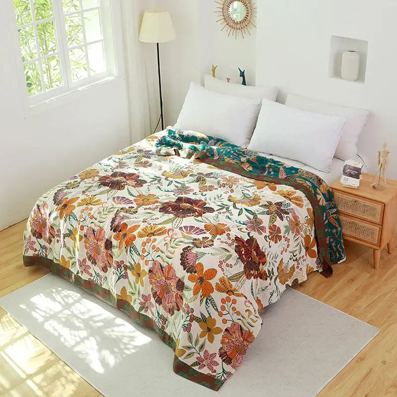 A cozy cream-colored cotton cover throw blanket with vibrant orange floral pattern and solid brown border for bedroom use