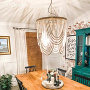 Boho tiered wooden beaded chandelier in light wood with gold-toned frame for dining room lighting