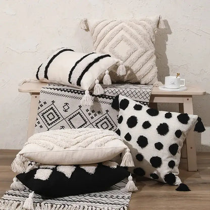 A collection of decorbites boho tufted beige and white pillow cover with black and white patterns and tassel decor