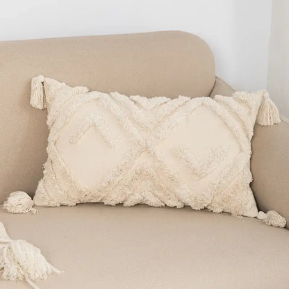 Cream-colored boho tufted beige pillow cover with textured fringed fabric and tassel decorbites tassels at corners